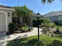 Inviting home entrance with lush landscaping, a welcoming path, and a charming lamp post at 10116 Reagan Dairy Trl, Bradenton, FL 34212
