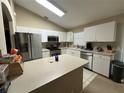 Bright kitchen with white cabinets, stainless steel appliances, and a functional center island at 10116 Reagan Dairy Trl, Bradenton, FL 34212