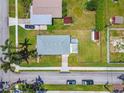 Bird's-eye view of home, showing its roof, lawn, and adjacent street with parked cars at 1200 25Th W Ave, Palmetto, FL 34221