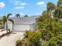 Exterior of home with 2-car garage and lush landscaping including many mature palms at 1312 Perico Point Cir, Bradenton, FL 34209