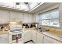 Well-lit kitchen with white cabinetry and views to the exterior at 1314 57Th W St # 1314, Bradenton, FL 34209