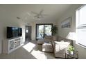 Bright living room featuring a comfortable sectional couch and a sliding glass door to a balcony at 16904 Vardon Ter # 208, Lakewood Ranch, FL 34211