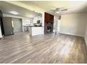 Bright open-concept living room featuring modern flooring, a brick fireplace, and an eat-in kitchen with stainless steel appliances at 1902 24Th W Ave, Bradenton, FL 34205