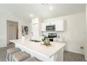 Modern kitchen featuring quartz countertops, stainless steel appliances, and a central island with seating at 22318 Alcorn Ave, Port Charlotte, FL 33952