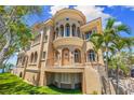 Luxurious home featuring a stucco facade, balcony, grand staircase and lush, green lawn at 290 N Washington Dr, Sarasota, FL 34236