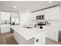 Bright kitchen features stainless steel appliances, a central island, and white cabinetry at 3108 Rock Sound St, Bradenton, FL 34208