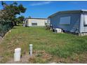 Lush backyard with green grass, utility connections and mobile homes providing a serene outdoor setting at 3212 Oakwood S Blvd, Sarasota, FL 34237