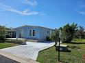 Inviting single-story home with a blue exterior, and a well-manicured lawn at 3212 Oakwood S Blvd, Sarasota, FL 34237