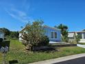 Well-maintained home showcasing a blue exterior, a meticulously landscaped yard and established trees at 3212 Oakwood S Blvd, Sarasota, FL 34237