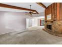 Open living room with a stone fireplace, beamed ceilings, and ample natural light at 3934 Brookside Dr, Sarasota, FL 34231