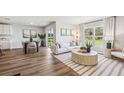 Bright living room features wood floors, neutral décor, and large windows overlooking the backyard at 4423 Dusky Dawn Ln, Palmetto, FL 34221