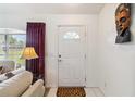 Bright entryway with a white door, tile flooring, and a glimpse of the living area, creating a welcoming ambiance at 4664 Hegira St, North Port, FL 34286