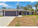 Charming single-story home with a well-manicured lawn, a two-car garage, and a welcoming front entrance at 4664 Hegira St, North Port, FL 34286