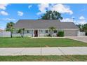Charming single-story home with mature palm trees, lush lawn, a red front door, and an attached garage at 4708 26Th W Ave, Bradenton, FL 34209