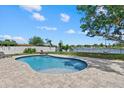 Sparkling kidney-shaped pool with a brick patio and views of the lake at 4708 26Th W Ave, Bradenton, FL 34209