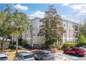 Building exterior showing a neutral color scheme, multiple windows, and mature trees in a parking lot at 5168 Northridge Rd # 106, Sarasota, FL 34238