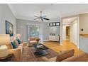 Neutral living room with wood floors, ceiling fan, and large window offering natural light at 5168 Northridge Rd # 106, Sarasota, FL 34238