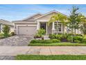 Inviting home with stone accents, beautiful landscaping, a two-car garage, and a cozy front porch at 5770 Long Shore Loop, Sarasota, FL 34238