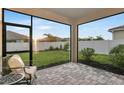 The screened lanai offers an outdoor living space with views of the backyard and a privacy fence at 5770 Long Shore Loop, Sarasota, FL 34238