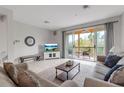 Bright living room featuring tile flooring, comfortable sofas, and balcony access at 603 Cedars Ct, Longboat Key, FL 34228