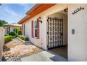 Close-up of the front door and entry, featuring an ornate security gate and colorful landscaping at 6701 12Th W Ave, Bradenton, FL 34209