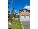 Side view of a well-maintained two-story home with a two-car garage, shed, and a meticulously kept lawn at 8412 Grove Blvd, Punta Gorda, FL 33982