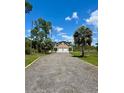Charming two-story home with a well maintained gravel driveway and a two-car garage under a bright, sunny sky at 8412 Grove Blvd, Punta Gorda, FL 33982