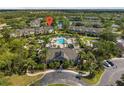 Breathtaking aerial view showcasing a community pool, clubhouse, and scenic lake, surrounded by lush landscaping at 8926 Manor Loop # 201, Lakewood Ranch, FL 34202