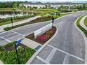 Scenic aerial view of Skye Ranch community entrance with lush landscaping and a tranquil pond at 9064 Driven Snow St, Sarasota, FL 34241