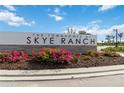 The Townhomes at Skye Ranch community sign with vibrant flowers and manicured landscaping at 9064 Driven Snow St, Sarasota, FL 34241