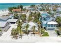 Aerial view of the cozy beach house nestled among lush palm trees near the ocean at 104 Magnolia Ave, Anna Maria, FL 34216