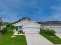Charming single-story home features a two-car garage, manicured lawn, and inviting curb appeal at 10962 High Noon Trl, Parrish, FL 34219