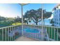 Balcony view of pool and bay with mature trees, providing a serene and picturesque setting at 1100 Imperial Dr # 507, Sarasota, FL 34236