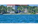 Exterior waterfront view of a multi-story building with lush landscaping and waterfront views at 1100 Imperial Dr # 507, Sarasota, FL 34236