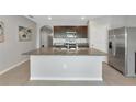 Bright kitchen features a large island with sink, stainless steel appliances, and granite countertops at 12712 Dusty Trail Dr, Sarasota, FL 34238