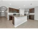 Stylish kitchen features an island, stainless steel appliances, granite countertops, and dark cabinets at 12712 Dusty Trail Dr, Sarasota, FL 34238