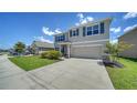 Beautiful two-story home with a well-manicured lawn, a two-car garage, and charming blue shutters at 12728 Lateral Root Dr, Sarasota, FL 34238