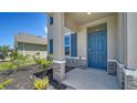Stylish front entrance with a vibrant blue door, stone accents, and meticulously maintained landscaping at 12728 Lateral Root Dr, Sarasota, FL 34238