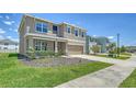 Charming curb appeal with manicured lawn and a welcoming covered porch of this two-story home at 12732 Lateral Root Dr, Sarasota, FL 34238