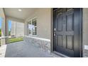 Close up on the stone detail accents, front door and covered porch of this charming home at 12732 Lateral Root Dr, Sarasota, FL 34238