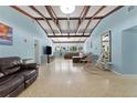 Spacious living room with exposed beam ceiling, terrazzo floors, and lots of natural light, perfect for entertaining at 138 Pearl Ave, Sarasota, FL 34243