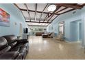 Spacious living room with exposed beam ceiling, terrazzo floors, and lots of natural light, perfect for entertaining at 138 Pearl Ave, Sarasota, FL 34243