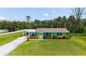 Charming single-story home boasts a colorful exterior, well-manicured lawn, and an attached carport at 156 Myakka Rd, Venice, FL 34293