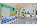 Covered patio with wicker furniture, a dining table, and string lights overlooks the inviting pool area at 156 Myakka Rd, Venice, FL 34293