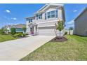 A charming two-story home featuring a manicured lawn and a two-car garage at 17330 Harvest Moon Way, Bradenton, FL 34211
