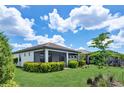 This is a charming back exterior with a manicured lawn and gorgeous plantings and a screened-in patio at 17725 Northwood Pl., Bradenton, FL 34202