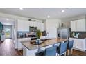 Modern kitchen featuring stainless steel appliances, sleek countertops, and an island with seating at 18303 Wheathouse Pl, Lakewood Ranch, FL 34211