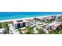 Stunning aerial view showcases beachfront condos with vibrant landscaping and easy beach access at 1945 Gulf Of Mexico Dr # M2-313, Longboat Key, FL 34228