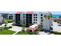 Charming condo building with red tile roofs and lush landscaping, offering a welcoming beachside retreat at 1945 Gulf Of Mexico Dr # M2-313, Longboat Key, FL 34228