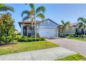 Charming single-story home with a red tile roof, lush landscaping, and a brick driveway at 197 Villoresi Blvd, Nokomis, FL 34275